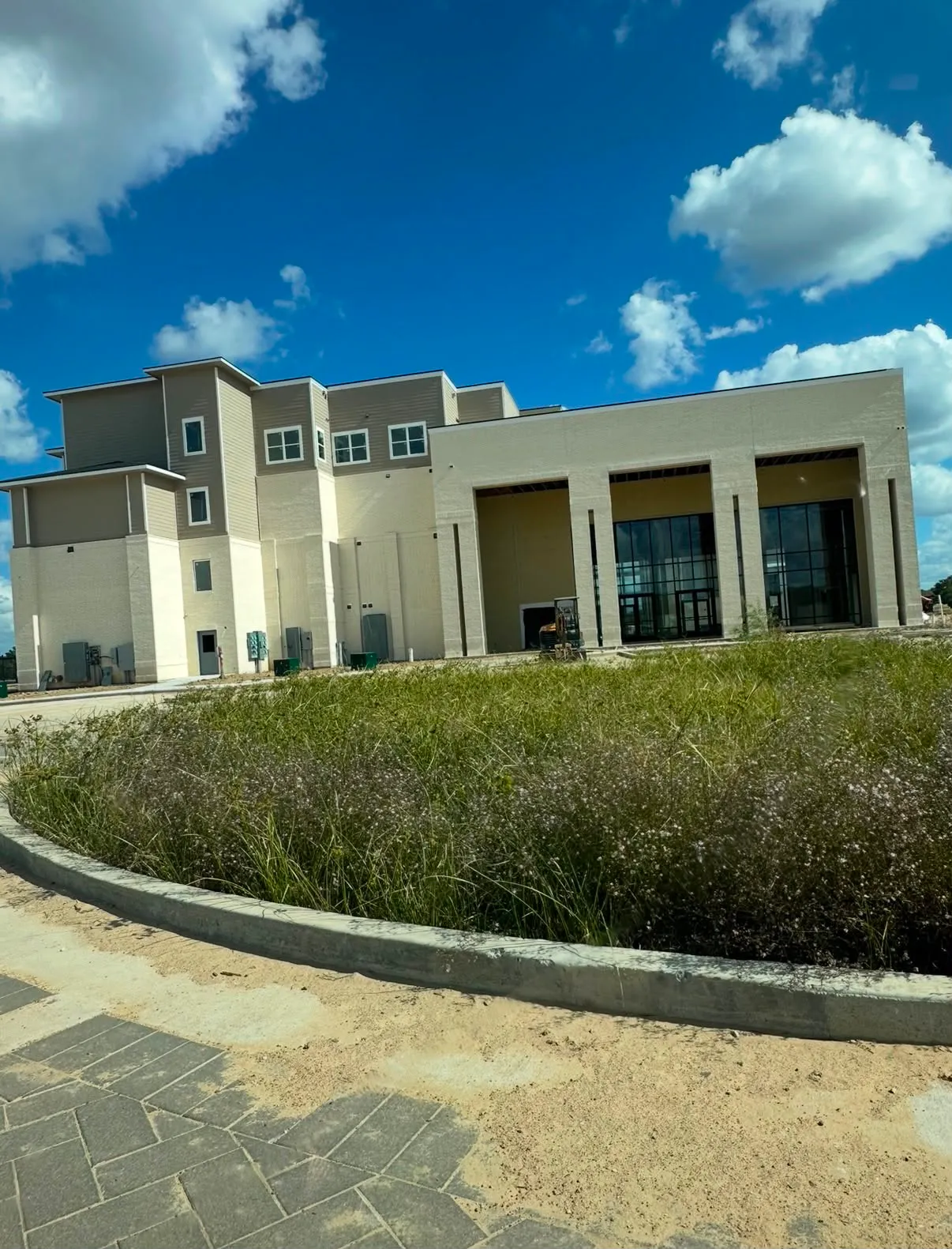Completed commercial building with brick columns and a landscaped entrance